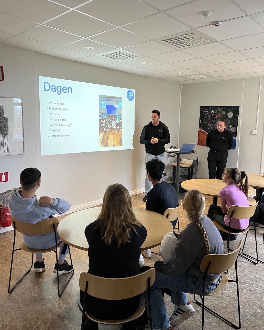 Unga ledare lyssnar på en utbildare som presenterar dagens agenda.