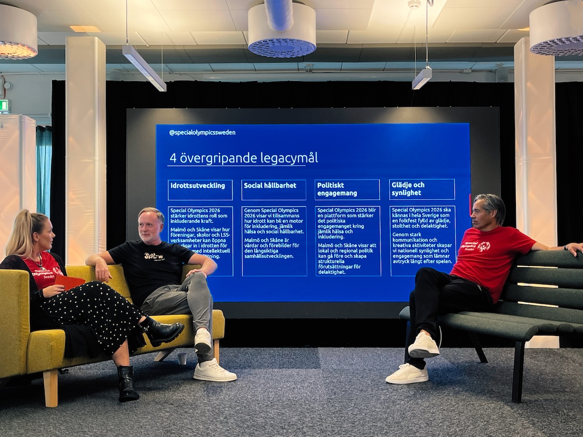 Ted Åhs på en scen tillsammans med Parasport Sverige. I bakgrunden visas en bild med Special Olympics 4 legacy-mål.