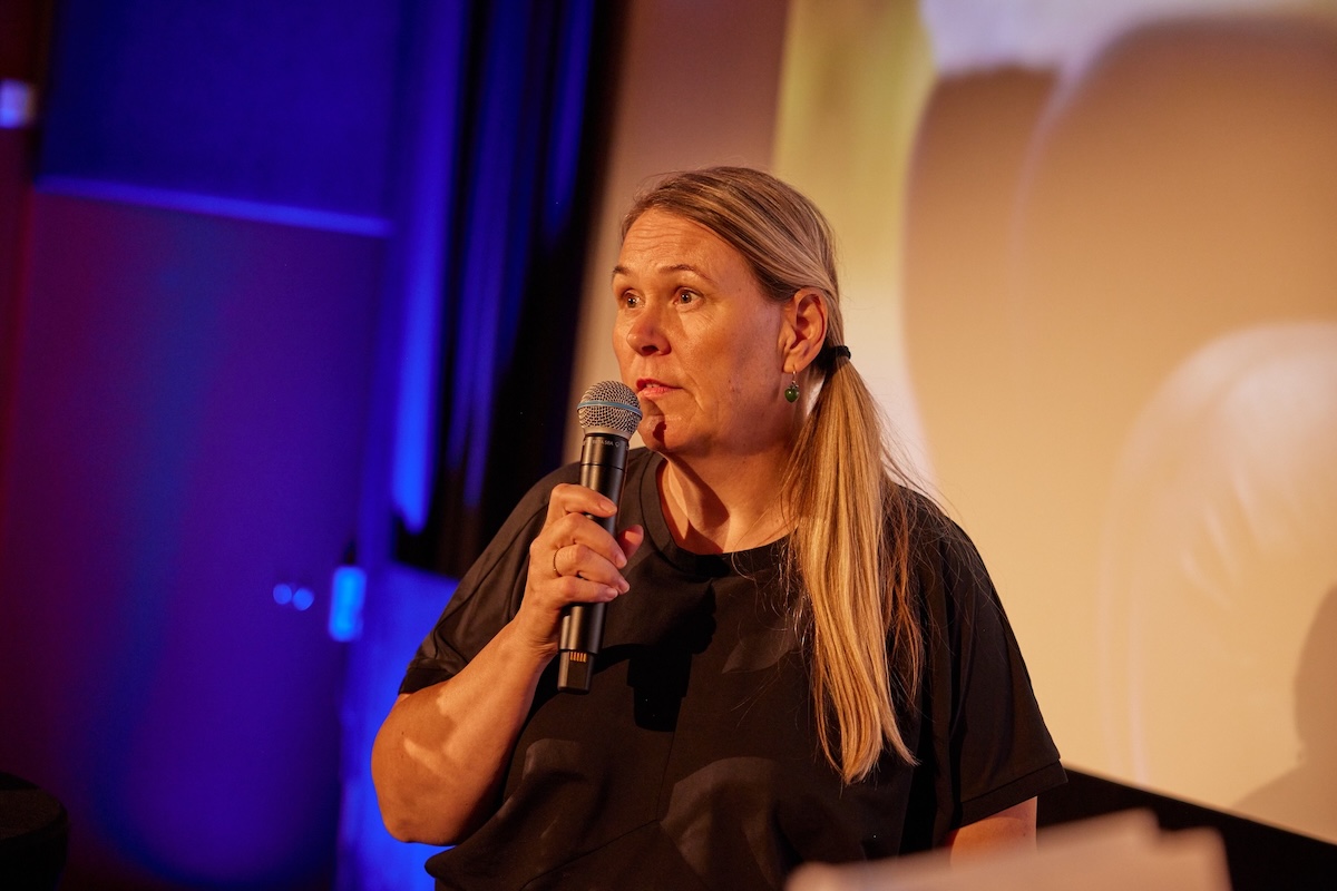 Carin Daal, chef för hållbarhet och kommunikation på Stena Fastigheter, håller i en mikrofon på scenen.